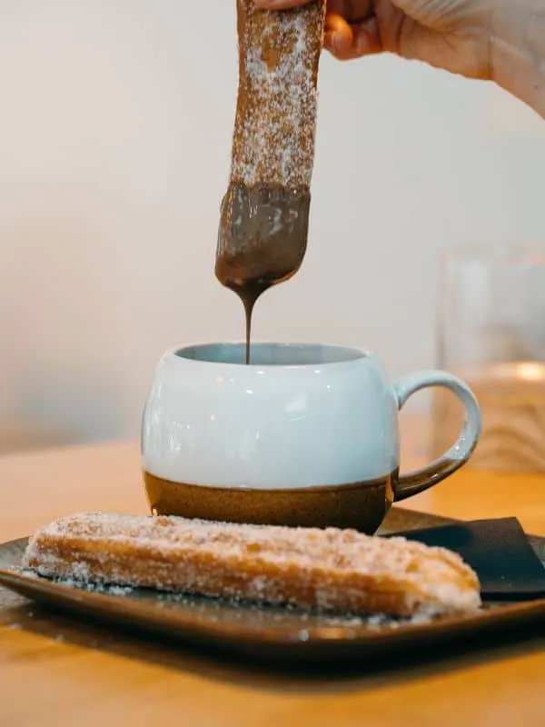 spanish dessert churros served with a cup of chocolate