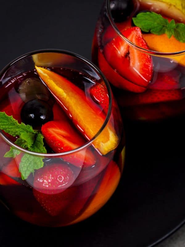 summer sangria recipe with red wine with various fruits in 2 glasses. Best Spanish alcoholic drinks