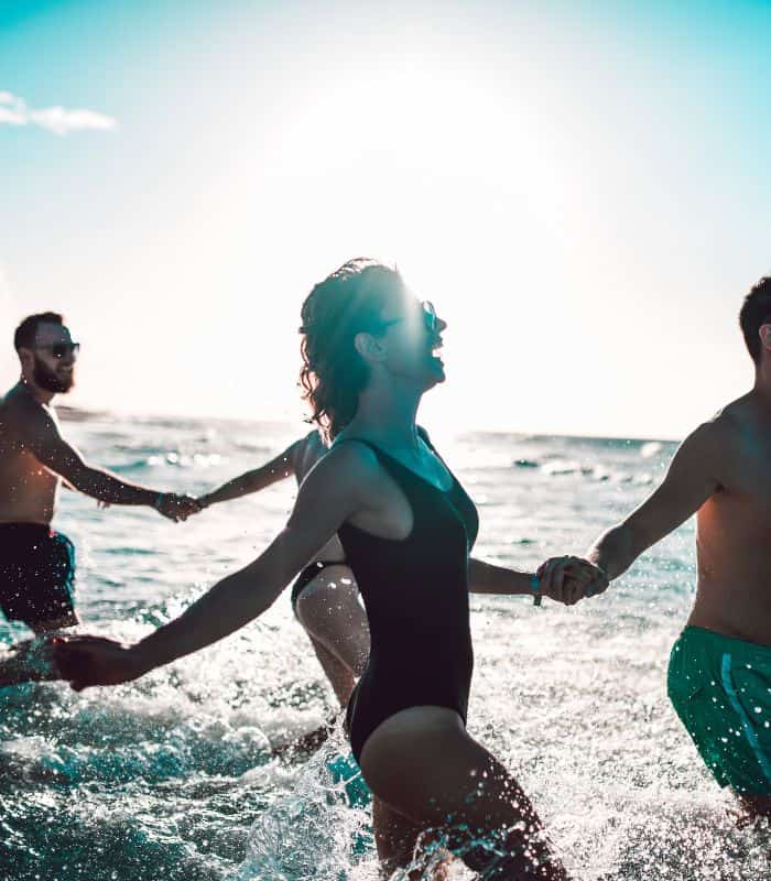 a group of friends entering the sea, enjoing the Malaga weather in September