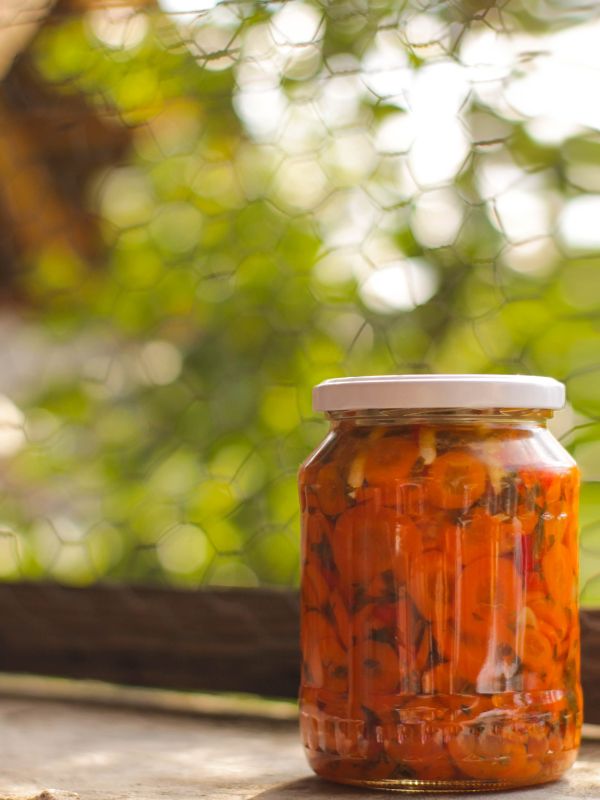 a jar of spanish pickled carrots on a table outside