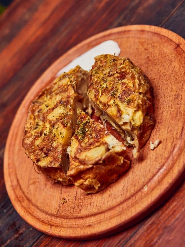 Tortilla del Sacromonte on a wooden board, a top food of Andalucia