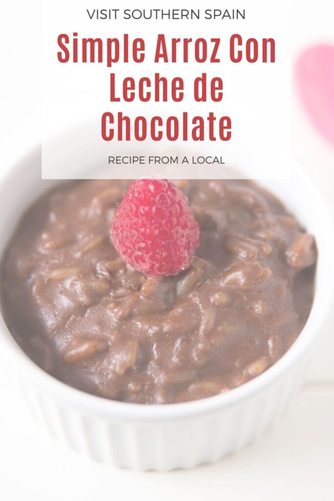 a pin with Arroz Con Leche de Chocolate in a bowl decorated with a raspberry
