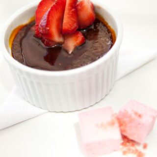 Chocolate Crema Catalana in a white bowl topped with strawberries
