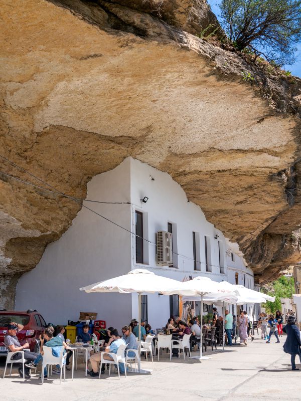 people at a terrace in Setenil de las Bodegas while visiting Andalucia in April - Discover Andalucia In April [ Insider Guide ]