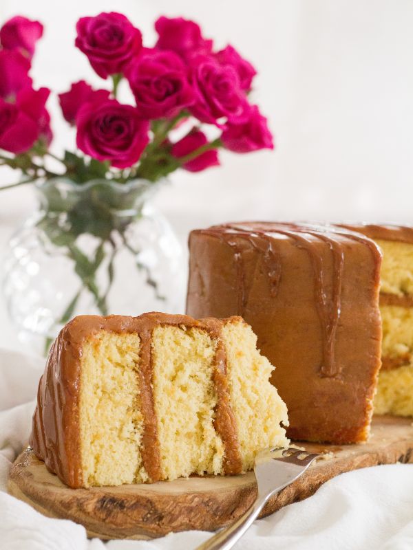 Dulce de leche filled sponge cake and vase with pink roses