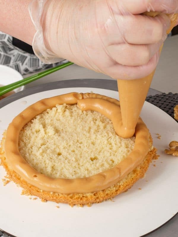 woman filling a Dulce de leche-filled sponge cake