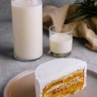 Dulce de leche layer cake on a plate and a bottle of milk next to it