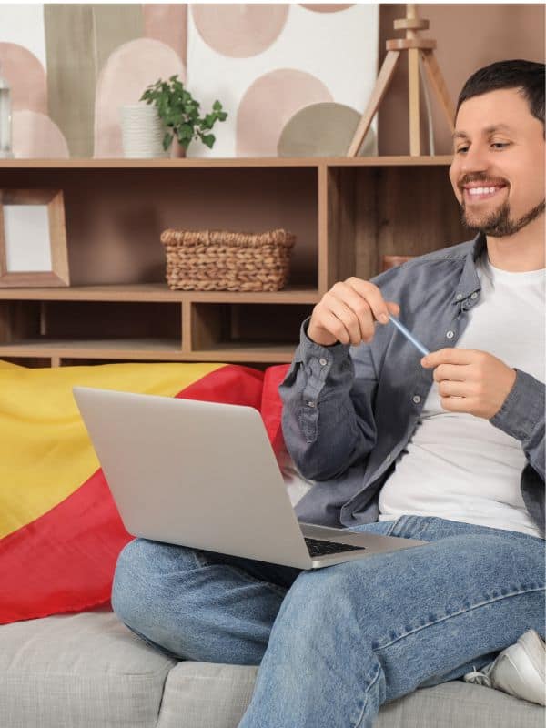man sitting on a couch to learn Spanish for travel